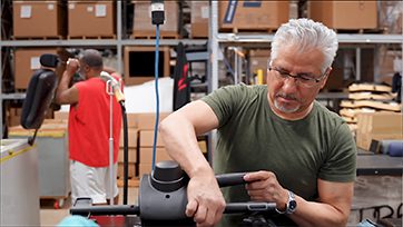 a man tests a chair in a warehouse testing facility