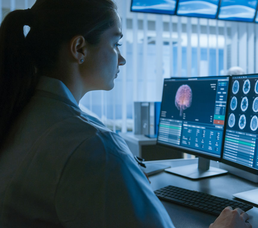 woman sitting in front of computer screens in hospital