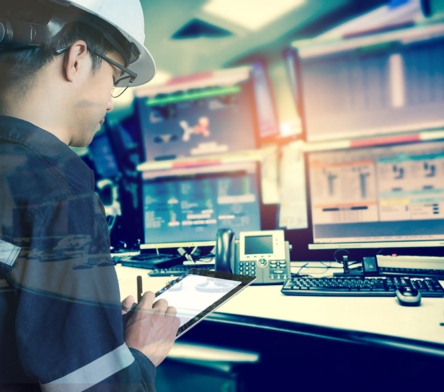 Miner working at a computer with multiple monitors