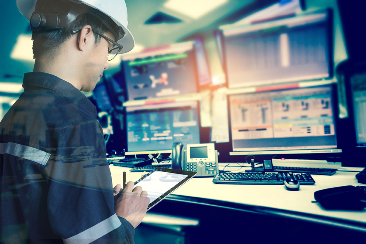 Miner working at a computer with multiple monitors