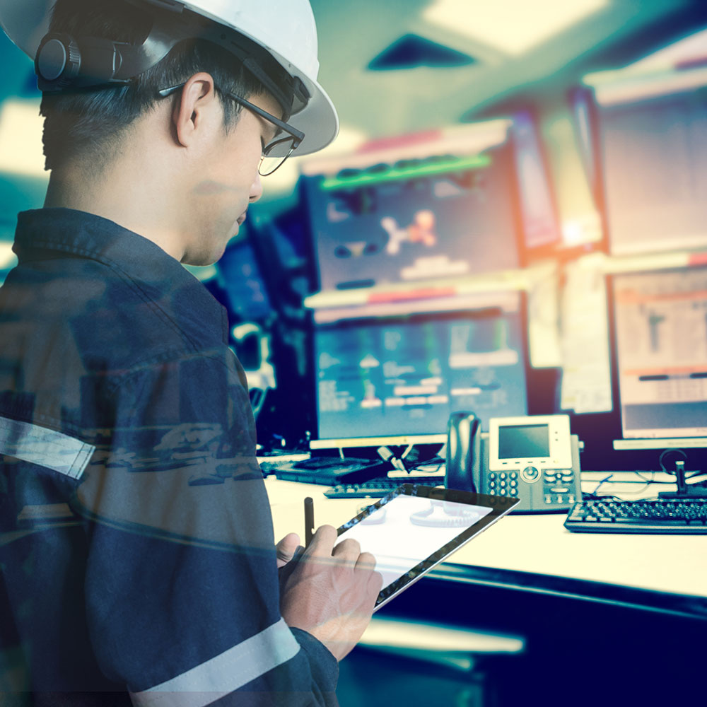 Miner working at a computer with multiple monitors